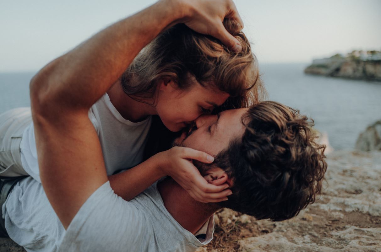 Couple kissing by ocean