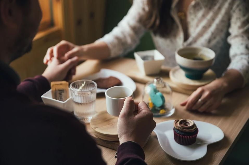Couple holding hands and drinking coffee