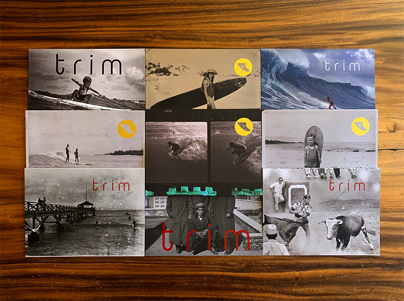 Nine trim magazine issues arranged on a table