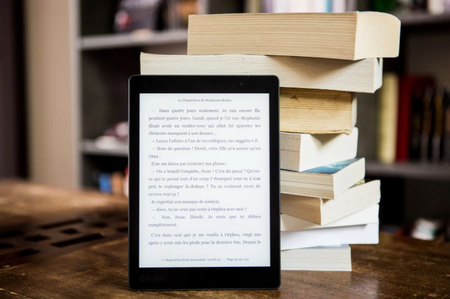 Pile of books with Kindle