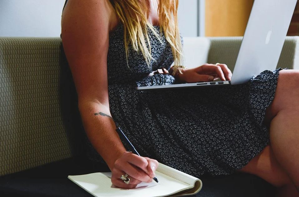 Girl typing and writing