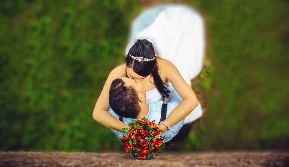 Couple kissing wedding bouquet