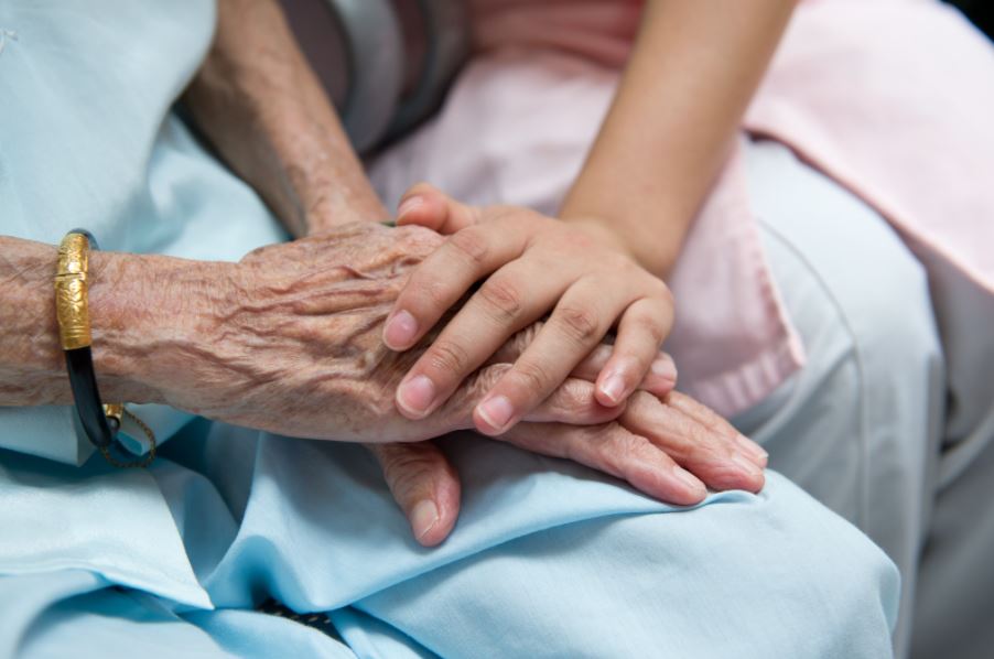 Young and old person holding hands