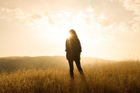 Woman standing at sunrise