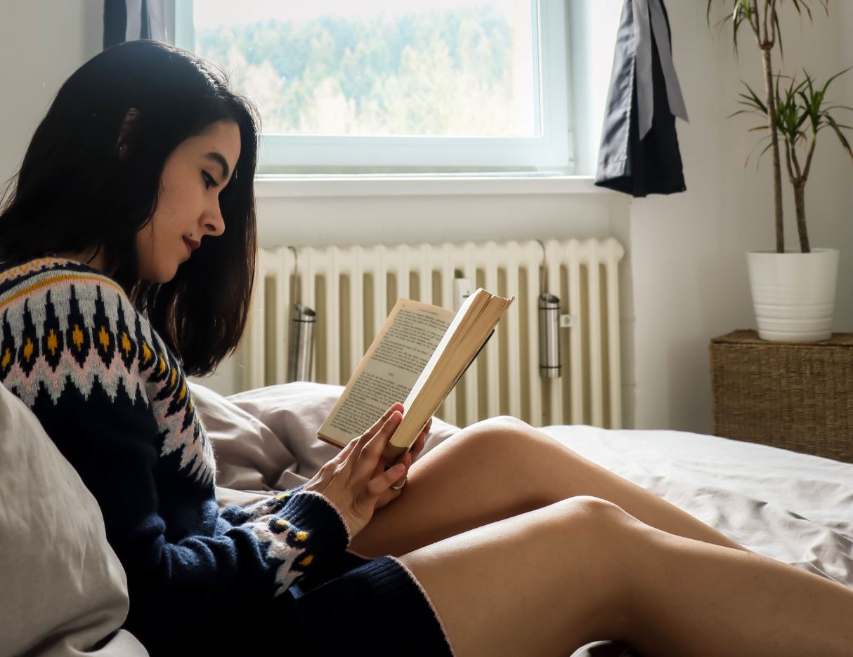 Girl reading book in bed
