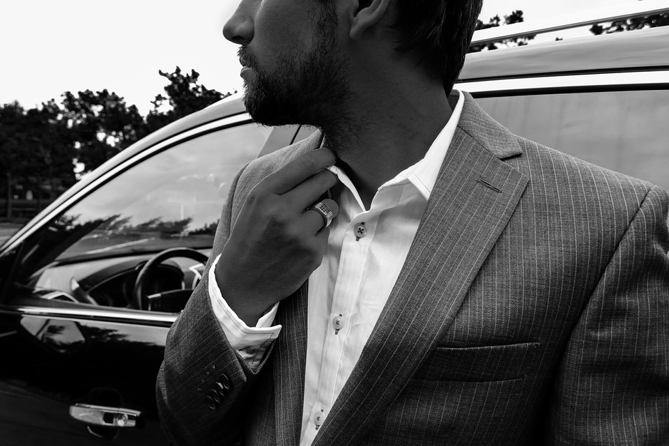 Man in suit in front of car