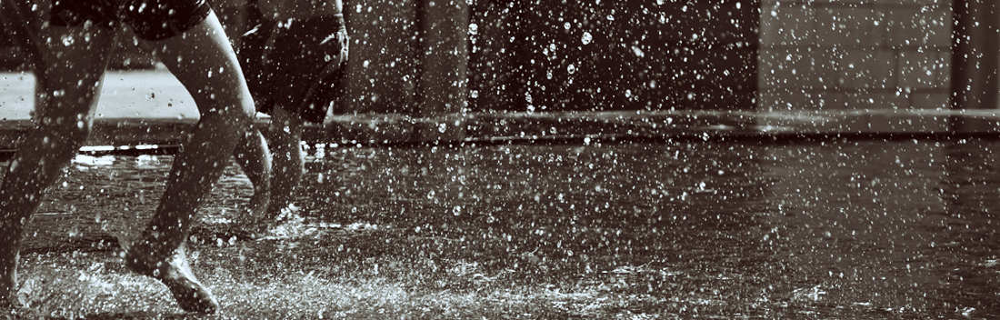 Crianças brincando numa chuva de gotas de água numa praça
