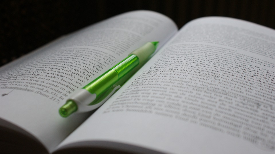 Open book with green pen