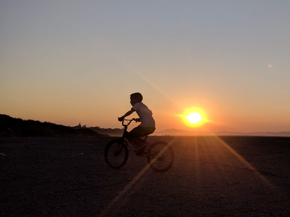 fietsend kindje bij zonsondergang