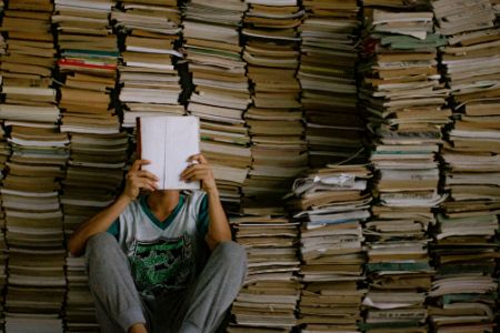 Man in front of big pile of books