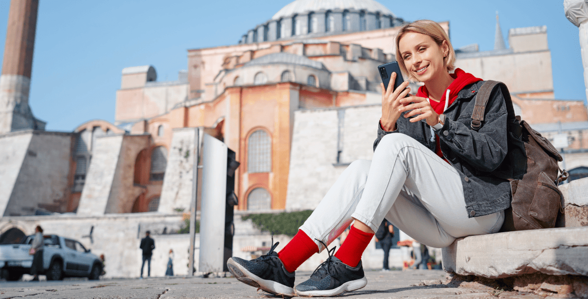 a lady sitting in front of Hagia Sophia