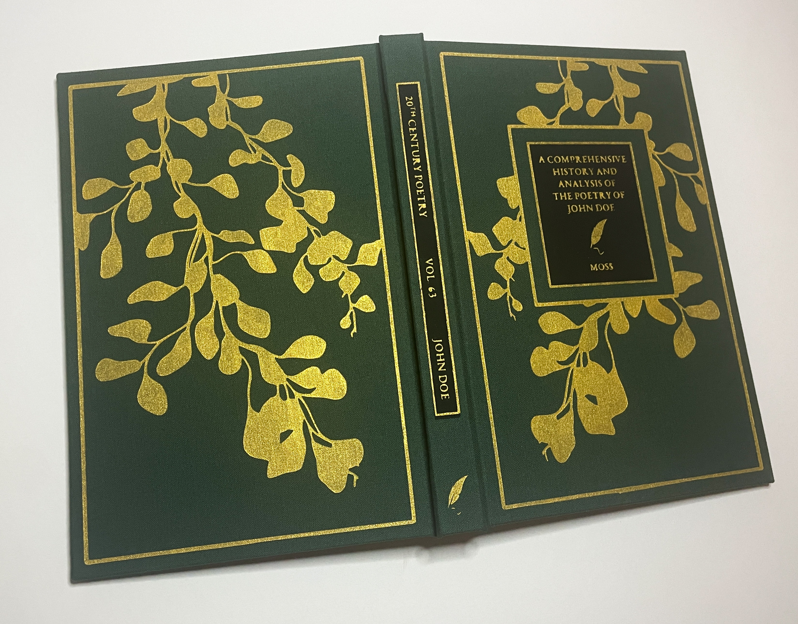A hand-bound book open and sitting face-down so both covers and the spine can be seen. There is a gold-painted vine pattern on the front and back covers, as well as a black rectangle on the front cover with the title and author name painted in gold. The spine also has a black rectangle with the words '20th century poetry, Vol. 63, John Doe' painted on it in gold. There is a gold quill on the bottom of the spine.