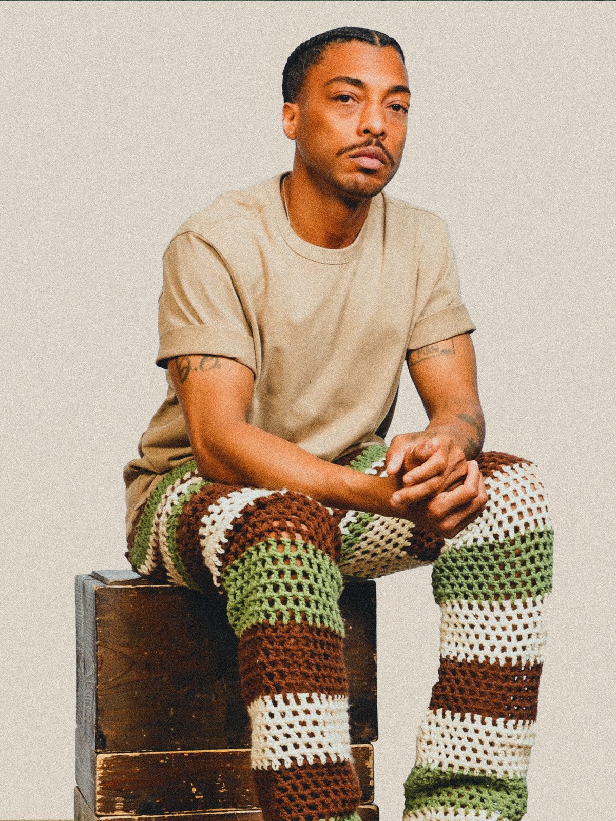 Byron seated in crocheted pants
