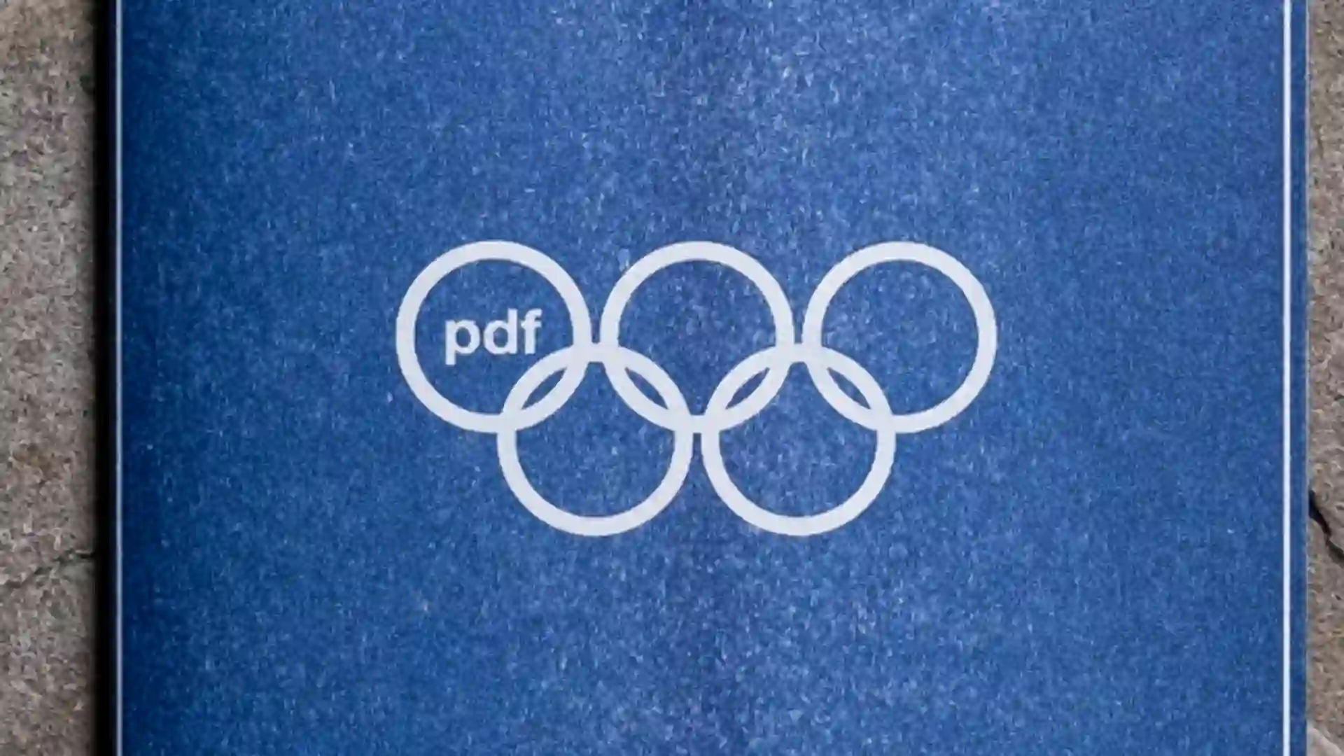 Archive PDF brand identity mockup featuring the pdf logo integrated into an Olympic style five ring symbol printed on a blue textured cover