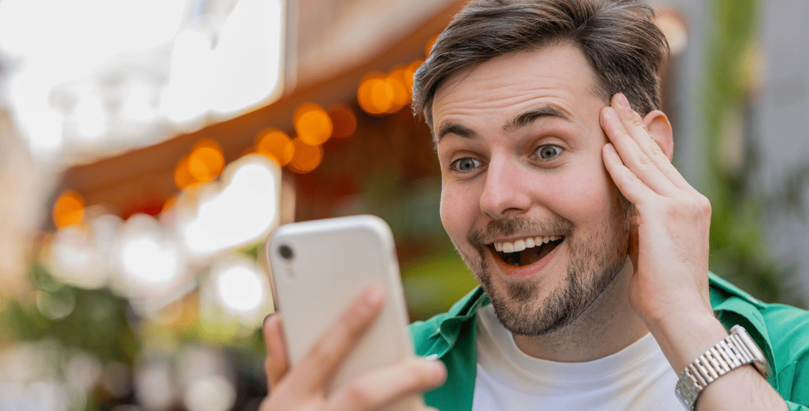a happy man looking to a phone