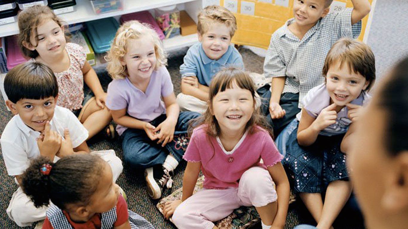 children sitting on the floor together, children smiling